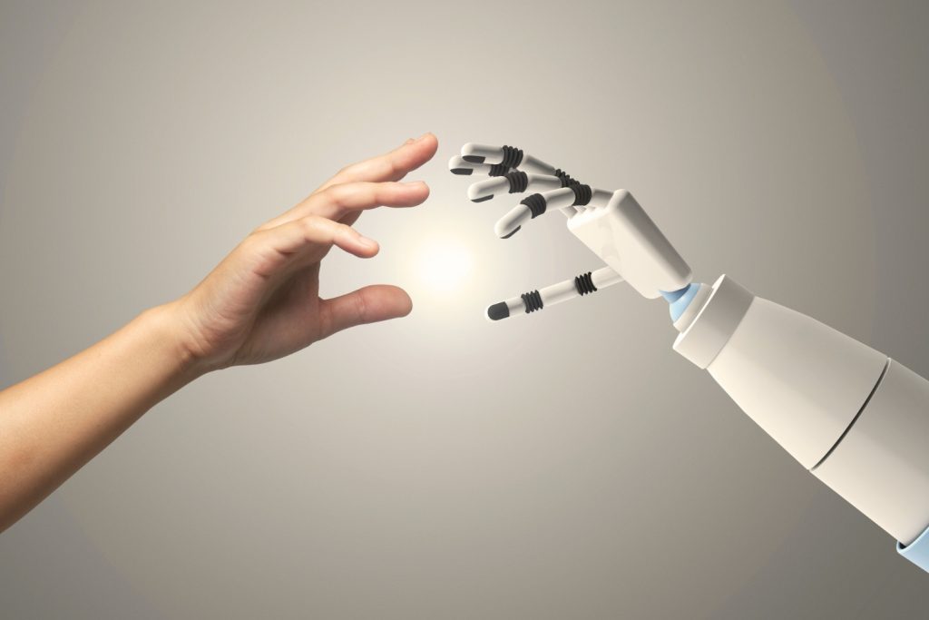 one robot hand and one human hand balancing human creativity and AI